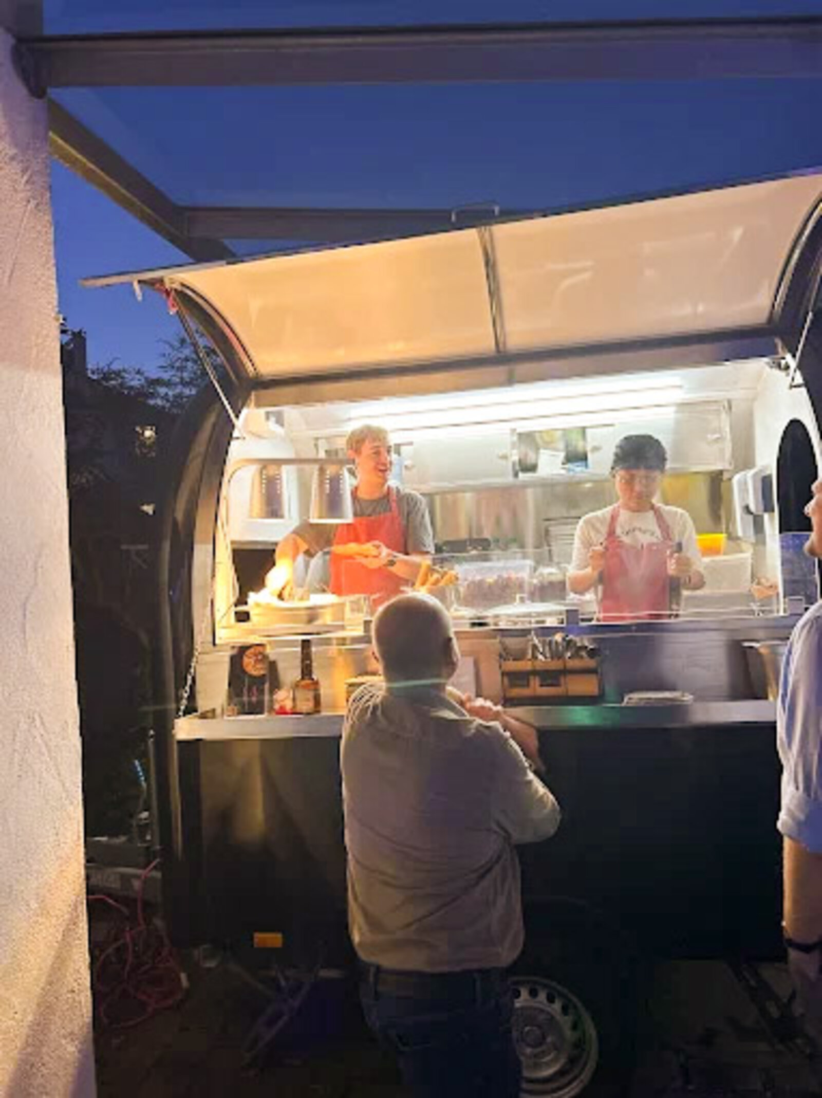 Foodtruck-Team beim Servieren am Abendmarkt