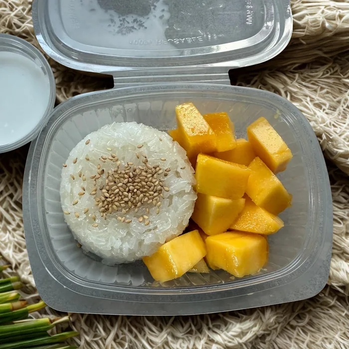 Mango Sticky Rice mit Sesam und Kokossoße in der Mitnahmebox